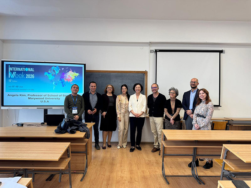 group of people standing in front of a classroom